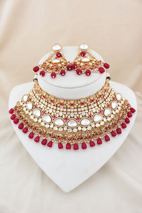 Necklace In Gold Polish With Kundan And Ruby Color Pearls Attached Also Large Earrings And Tikka(NK004-RU-K-B1)