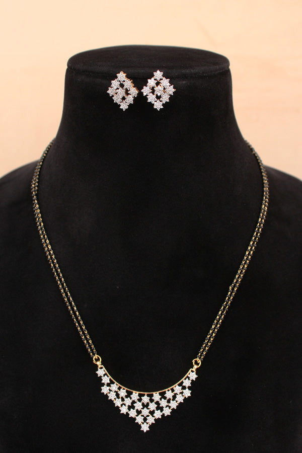 Necklace and earrings set on a black velvet stand with a beige background
